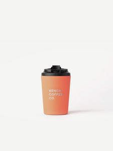 Made by Fressko reusable cup, with BENCH COFFEE CO. logo, in coral